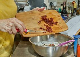 chefe de cozinha cortes seco ao sol tomates para adicionar para a prato foto