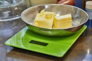 manteiga dentro metal prato em digital escala dentro casa cozinha foto