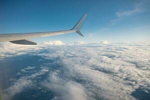 asa do a avião vôo sobre branco nuvem dentro a céu durante a período de férias foto