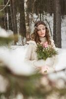 lindo noiva dentro uma branco vestir com uma ramalhete dentro uma coberto de neve inverno floresta. retrato do a noiva dentro natureza foto