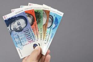 finlandês dinheiro dentro a mão em uma cinzento fundo foto