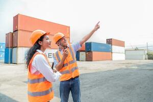 manutenção trabalhador trabalhando com carga containers. engenheiro dentro segurança capacete, reflexivo colete, segurando walkie talkie com recipiente exportação e importar o negócio e logística fundo. foto