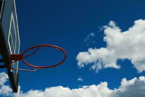 vermelho basquetebol aro em a céu fundo foto