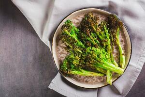 fechar acima do frito verde brócolis brotos em uma prato em a mesa topo Visão foto