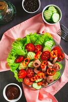 salada do frito salsichas, tomates, pepino e alface em uma prato topo e vertical Visão foto