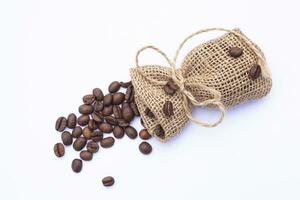 grãos de café no saco isolado no fundo branco foto