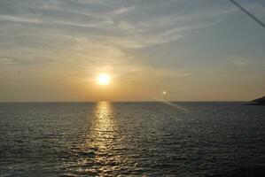 uma iate às pôr do sol em a mar superfície. pôr do sol com uma do iate silhueta, Tailândia foto