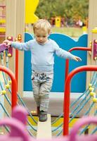 fofa pequeno Garoto jogando dentro uma Parque infantil foto