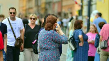 Varsóvia, Polônia. 29 Julho 2023. multidão do pessoas caminhando em uma rua. uma multidão comovente contra uma fundo do a urbano velho cidade panorama. foto