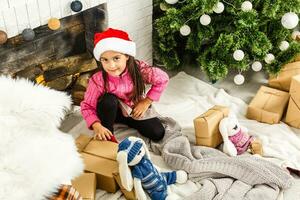 pequeno menina decoração a Natal árvore foto