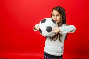 pequeno menina com a bola sobre vermelho background foto