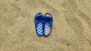 azul chinelos em a de praia em a Beira Mar. foto