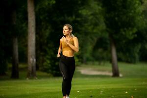 bonita jovem mulher corrida dentro a parque foto