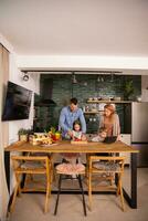 jovem família preparando legumes dentro a cozinha foto