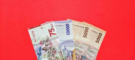 topo Visão do Novo notas emitido dentro 2022. indonésio rupia moeda isolado em vermelho fundo foto