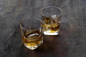 vista superior de whisky com gelo em vidro na mesa de madeira foto