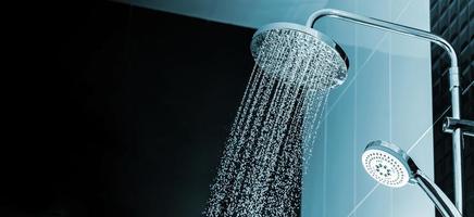 close-up da água fluindo do chuveiro no interior do banheiro foto