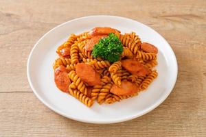 macarrão espiral ou espiral com molho de tomate e salsicha - comida italiana foto