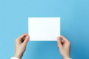 uma humano mão segurando uma em branco Folha do branco papel ou cartão isolado em azul fundo. ai gerado foto
