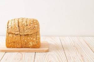 pão integral fatiado em uma mesa de madeira foto