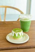 bolo de queijo matcha chá verde com xícara de chá verde na mesa em um café restaurante foto