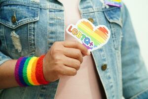 mulher asiática com bandeira do arco-íris, direitos do símbolo lgbt e igualdade de gênero, mês do orgulho lgbt em junho. foto