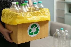 casa reciclar eco verde zero conceito mulher jogando esvaziar plástico garrafa dentro reciclando bin com amarelo lixo bolsas às lar. foto