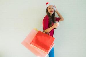 retrato lindas jovens mulheres asiáticas usam chapéu de Papai Noel de natal com sacola de compras foto