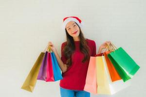 retrato lindas jovens mulheres asiáticas usam chapéu de Papai Noel de natal com sacola de compras foto