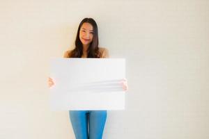 retrato de belas jovens mulheres asiáticas mostra um quadro de papel em branco foto