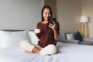 retrato de belas jovens mulheres asiáticas sorriso feliz com café e telefone celular foto