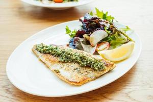 Bife de peixe de robalo grelhado com vegetais foto