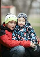 dois adorável jovem irmãos ao ar livre dentro inverno foto