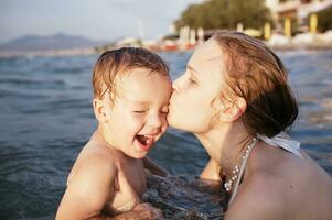 mãe se beijando dela jovem criança foto