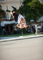 homem fazendo acrobático truques dentro cidade rua foto