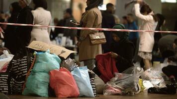 fêmea ajuda trabalhador distribuindo roupas às caridade colecionar ponto dentro copenhaga Ferrovia estação foto