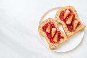 pão integral caseiro com geléia de morango e morango fresco foto