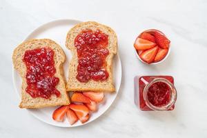 pão integral caseiro com geléia de morango e morango fresco foto