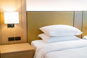 decoração de travesseiro branco na cama no quarto do hotel resort foto