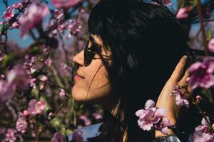 mulher entre a bonita Rosa pêssego árvore flores foto