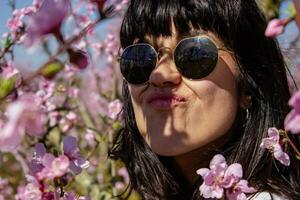 mulher entre a bonita Rosa pêssego árvore flores foto