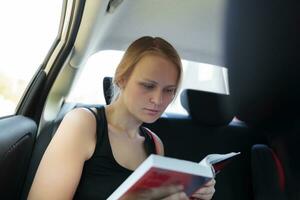 mulher lendo uma livro dentro a carro foto