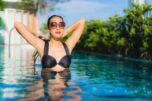 retrato lindas jovens mulheres asiáticas sorriso feliz relaxe piscina ao ar livre no resort foto