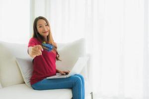 retrato de belas jovens mulheres asiáticas usando computador laptop com celular e cartão de crédito foto