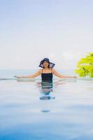 retrato lindas jovens mulheres asiáticas sorriso feliz relaxe piscina ao ar livre no hotel foto