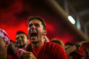 uma grupo do apaixonado fãs rugido dentro excitação Como a futebol estação chutes fora com uma emocionante jogos foto