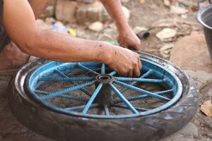 a indonésio serviço trabalhador é mudando a pneu do uma bicicleta carrinho manualmente foto