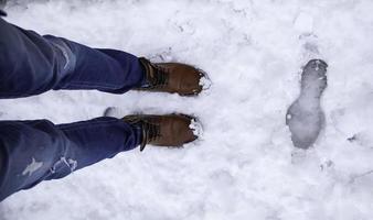 pés do homem na neve foto