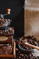 natureza morta com grãos de café e antigo moinho de café no fundo rústico foto
