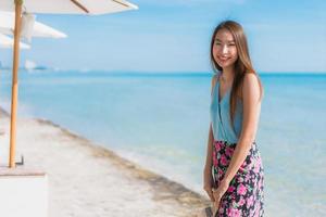 retrato bela jovem asiática feliz sorriso relaxar ao redor da praia, oceano e mar foto